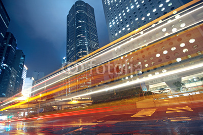 traffic light trails in the street by modern building