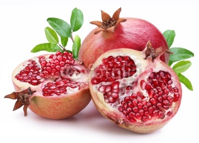 Juicy opened pomegranate with leaves.