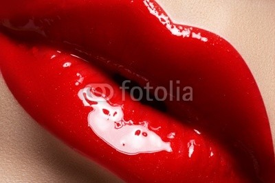 Close-up of lips with bright fashion red glossy makeup