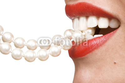 woman smiles showing white teeth and pearly necklace